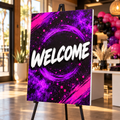 Custom rectangular foam board sign displayed on an easel at an event, with purple and pink printed artwork; easel shown for display only